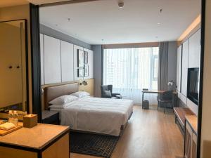 a bedroom with a bed and a desk and a television at Four Points by Sheraton Datong Pingcheng in Datong