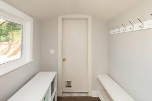 a white hallway with white walls and a window at Charming Cozy Cottage with Hot Tub in Coeur d'Alene +28 photos