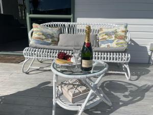 a bottle of wine on a table next to a bench at Make memories at Cook Drive in Whitianga