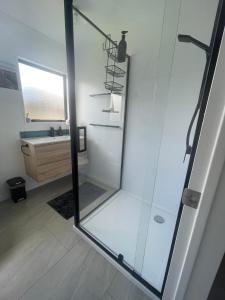 a glass shower in a bathroom with a sink at Make memories at Cook Drive in Whitianga