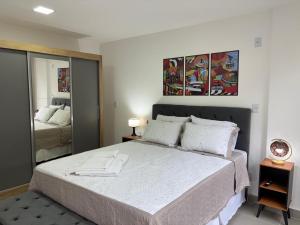 a bedroom with a large bed and a mirror at Studio próximo Museu do Amanhã in Rio de Janeiro