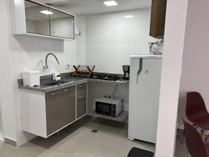 a kitchen with a sink and a microwave at Studio próximo Museu do Amanhã in Rio de Janeiro