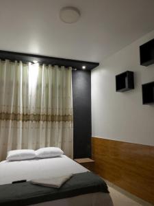 塔拉波托Descanso tropical 1的一间卧室配有一张带窗帘的大床