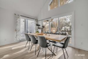 ein Esszimmer mit einem Holztisch und Stühlen in der Unterkunft Artémis - Paisible et Familial - Spa privé in Sainte-Catherine