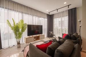 a living room with a couch and a flat screen tv at Triple Four in Bangkok