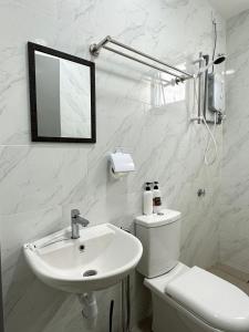 a white bathroom with a sink and a toilet at Leisure Home - 7pax Camping Theme in Kampong Lobok