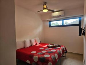 a bedroom with a red bed with a ceiling fan at Céntrico Estudio Con Roof Top Zona Romántica 502 in Puerto Vallarta +36 photos