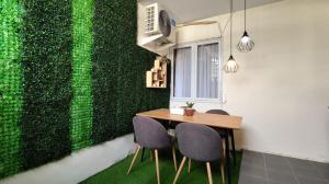 CipernaにあるNUTEN Homestay Syariahの緑の壁のダイニングルーム(テーブル、椅子付)