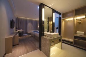 un bagno dell'hotel con lavandino e letto di Echarm Hotel Changsha Foreign Economics Institute Branch a Leifeng