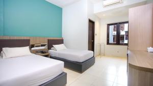 מיטה או מיטות בחדר ב-Sun In Pangandaran Hotel
