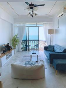 un salon avec un canapé et une table dans l'établissement Glory Beach Duplex Ocean View - 8Pax 3BR & FREE Disney Hotstar, à Port Dickson