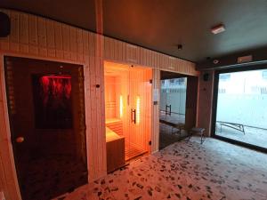 Cette chambre dispose d'une grande porte en verre et d'une fenêtre. dans l'établissement LUKSUSOWY APARTAMENT przy Plaży, à Grzybowo