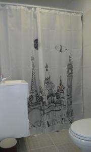 a bathroom with a shower curtain with a drawing of cities at Agua De Coco in Villa Gesell +63 photos