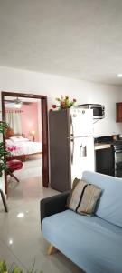 ein Wohnzimmer mit Couch und Küche in der Unterkunft Casa Gacela Cozumel in Cozumel