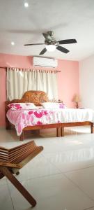 ein Schlafzimmer mit einem Bett und einem Deckenventilator in der Unterkunft Casa Gacela Cozumel in Cozumel