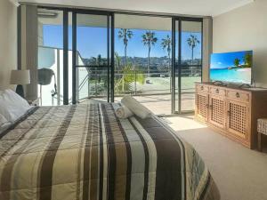 una camera da letto con un letto grande e una grande finestra di Unit 19 - Avoca Palms Resort ad Avoca Beach