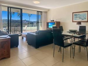 un soggiorno con un divano e un tavolo con sedie di Unit 19 - Avoca Palms Resort ad Avoca Beach