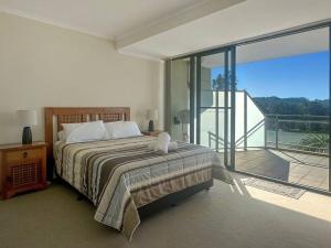 una camera da letto con un letto e un balcone di Unit 19 - Avoca Palms Resort ad Avoca Beach