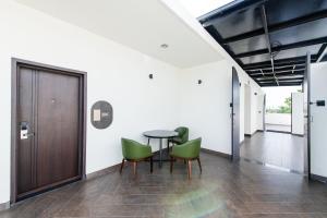 a dining room with a table and green chairs at Hotel Mysore Radiance in Mysore