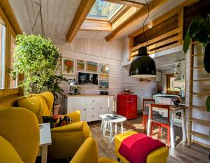 ArnoldshammerWichtelhaisl Rittersgrün im Erzgebirge - Entspannen im fröhlichen Tiny House - umzäunter Naturgarten-Hunde willkommen-Ebike und Elektroauto laden的客厅里有黄色的椅子和桌子