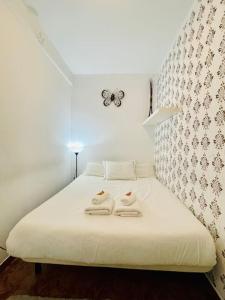 a bed with two towels on it with a butterfly on the wall at Plaza España - Cómodo y luminoso con balcón y wifi in Barcelona