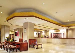 a hotel lobby with a table and chairs and a bar at The Howard Plaza Hotel Taipei in Taipei