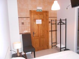 Habitación con puerta de madera y silla en Hospedaje Nuestra Señora de Ujue, en Tafalla