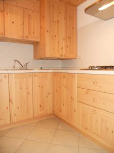 uma cozinha com armários de madeira e um lavatório em Casa Vacanze Villa Elena em Alleghe