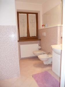 baño con 2 aseos y lavamanos en Casa Vacanze Villa Elena en Alleghe