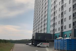 a large building with a white van parked in a parking lot at Riverdale Cikarang by Veto Rooms in Tanahbaru