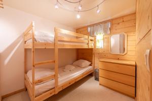 a bedroom with two bunk beds and a tv at Résidence Grand Roc - Campanules 317 - Happy Rentals in Chamonix-Mont-Blanc