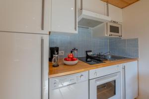 a kitchen with white cabinets and a counter top at Résidence Grand Roc - Campanules 317 - Happy Rentals in Chamonix-Mont-Blanc