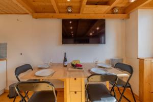 a dining room with a table with chairs and a television at Résidence Grand Roc - Campanules 317 - Happy Rentals in Chamonix-Mont-Blanc