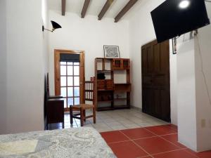 a bedroom with a bed and a tv in a room at Plaza San Cayetano Panoramic House in Guanajuato