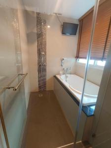 ein Badezimmer mit Badewanne, Waschbecken und Dusche in der Unterkunft J Residence Thonglor 8 in Bangkok