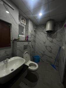 RājpurThe GreyDen的带白色水槽和马桶的浴室