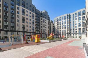 a playground in the middle of a city with tall buildings at Oasis апартаменты возле Триумфальной арки in Astana