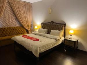 a bedroom with a bed with a red robe on it at Royal Service Apartments Gulberg in Lahore