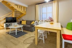 a living room with a table and a couch at Osada Cztery Pory Roku Czorsztyn in Czorsztyn