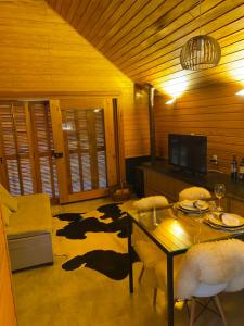 Una sala de estar con una mesa y una alfombra de vaca. en Cabana I com Banheira Hidro e Lareira - Chalet Mont Blanc - Urubici, en Urubici