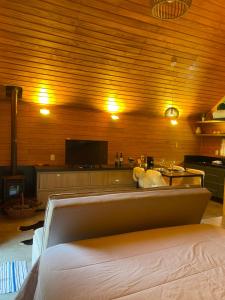 Un dormitorio con una cama y un televisor de pantalla plana. en Cabana I com Banheira Hidro e Lareira - Chalet Mont Blanc - Urubici, en Urubici