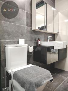 a bathroom with a white toilet and a sink at Almas Suites Cozy Relax Studio Seaview BySTAY in Nusajaya