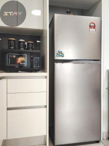 a kitchen with a microwave and a refrigerator at Almas Suites Cozy Relax Studio Seaview BySTAY in Nusajaya