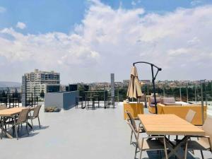 a patio with tables and chairs on a roof at Kigali Oasis luxury Apartment No 606 in Kigali