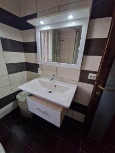 a bathroom with a white sink and a mirror at Apartament 2 camere in Bacău