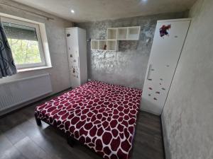 a bedroom with a bed with a red comforter at Apartament 2 camere in Bacău +4 photos