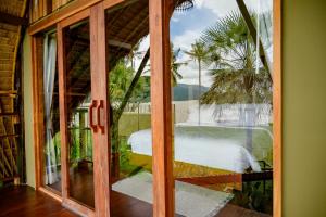 an open glass door with a view of a table at Earth Elements Eco Resort in Ban Bu Hua Chang