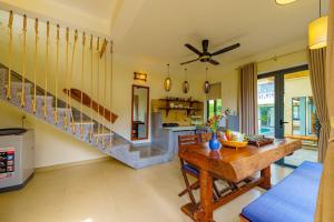 Una sala de estar con una mesa y una escalera. en May Hoian Pool Villa, en Tân Thành (1)