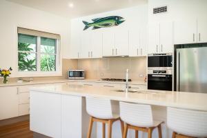 a kitchen with a counter with a fish on the wall at Echo Beach House in One Mile