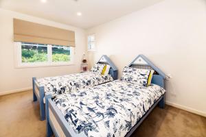 a bedroom with two beds and a window at Echo Beach House in One Mile +47 photos